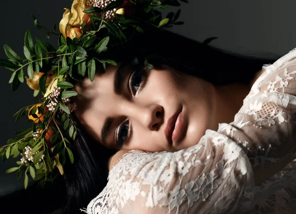 Schönes Porträt einer jungen Frau mit Blumenkranz auf dem Fußboden liegend — Stockfoto