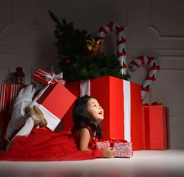 Asijské dítě dítě dítě dívka sedící v červené čepice santa s velkou vánoční — Stock fotografie