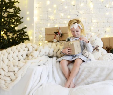 Genç kız oturma büyülü yeni yıl zanaat hediyeler bir Noel ağacı tarafından rüya bebek