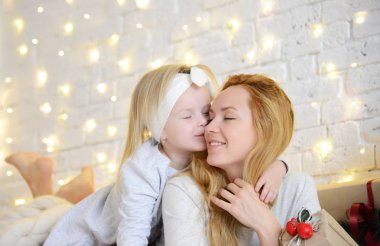 Genç anne ve büyülü yeni yıl hediyeleri bir Noel ağacı tarafından yalan sağlığınla kızları