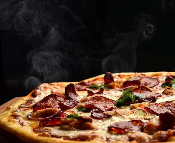 Pizza de pepperoni grande caliente sabrosa composición de pizza con queso derretido tocino tomates jamón pimentón vapor humo — Foto de Stock
