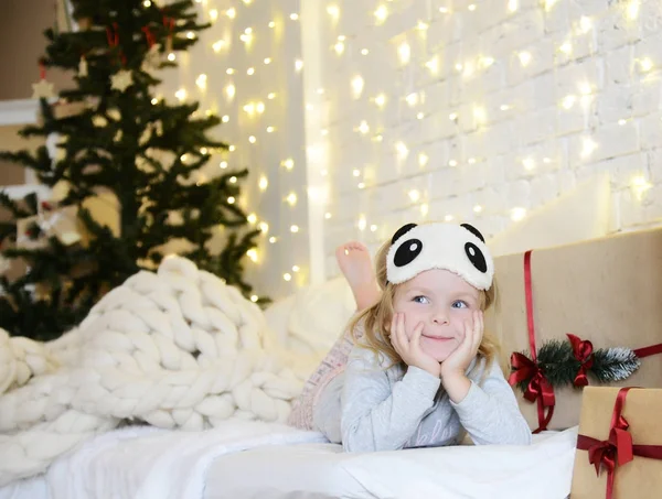 Ung baby flicka sittande drömmer nära magiska nyår hantverk gåvor av en julgran — Stockfoto