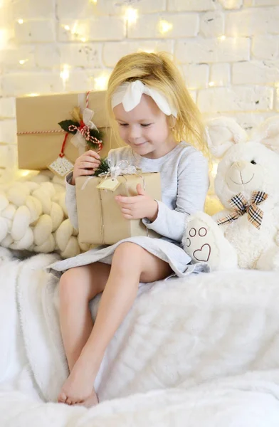 Junges Mädchen sitzt träumend in der Nähe von magischen Neujahrsgeschenken am Weihnachtsbaum — Stockfoto