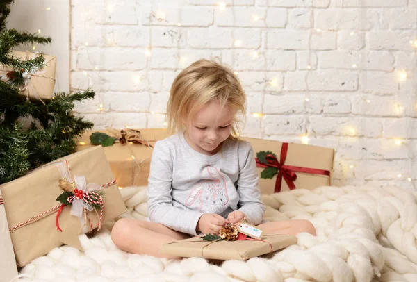 Genç kız oturma büyülü yeni yıl zanaat hediyeler bir Noel ağacı tarafından rüya bebek