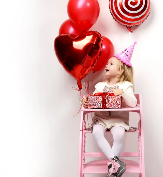 Bambina bambina festeggia il suo compleanno con regalo rosso e palloncini — Foto Stock