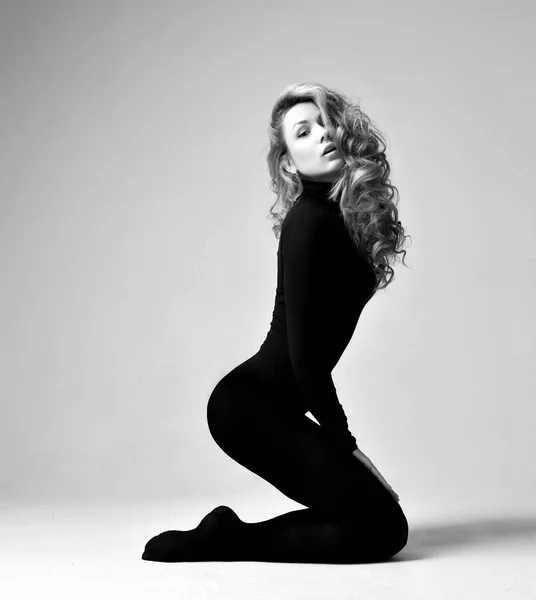 Jovem bela hipster menina mulher posando em longo escuro corpo pano sentado em seus joelhos olhando para a câmera — Fotografia de Stock