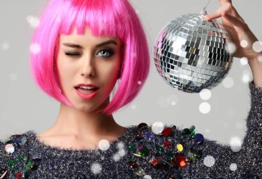 Şık pembe kanat Noel dekorasyon disko topu ile göz kırpıyor içinde genç güzel moda kadın portresi 