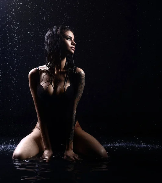 Joven hermosa mujer sentada bajo la lluvia gotas de agua ducha chapoteo —  Fotos de Stock