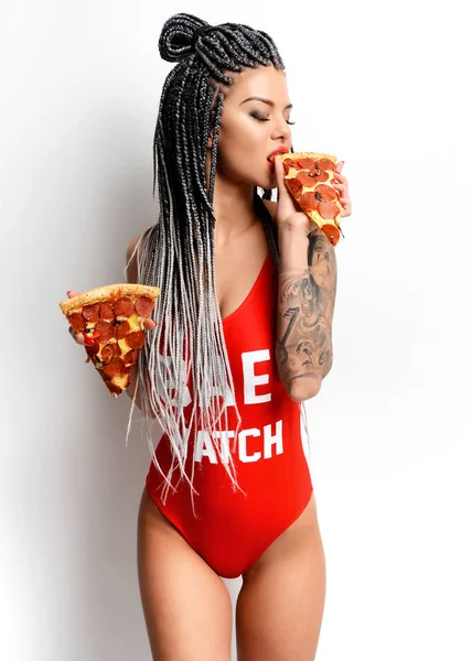 우아한 빨간 몸 조끼에 험 상을 젊은 아름 다운 섹시 한 여자 먹는 페퍼로니 피자 슬라이스 — 스톡 사진