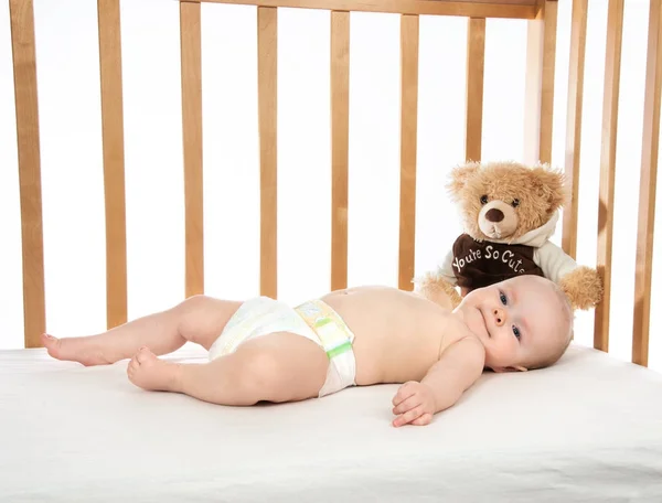Dítě dítě dívka batole ležící v posteli v plenka s Medvídek — Stock fotografie