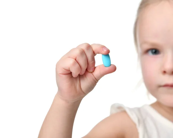 Giovane bambina tenere pillola pillola azzurra mal di testa medicina in mano piccola — Foto Stock