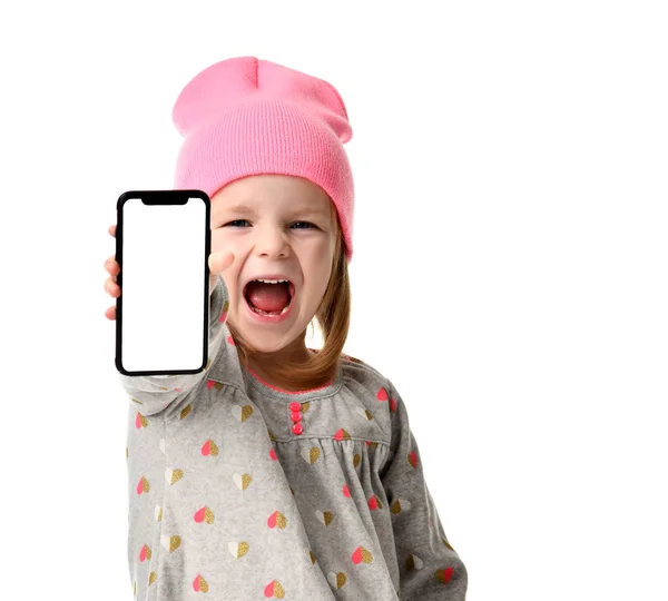 Smiling screaming little pretty girl in pink modern hat showing blank screen of mobile phone — Stock Photo, Image