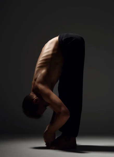 Homme pratiquant le yoga padahastasana asana pose — Photo