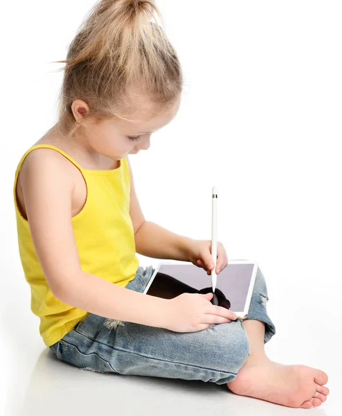 Young girl kid sitting reading learning drawing on digital tablet touch screen pad with pencil — Stock Photo, Image