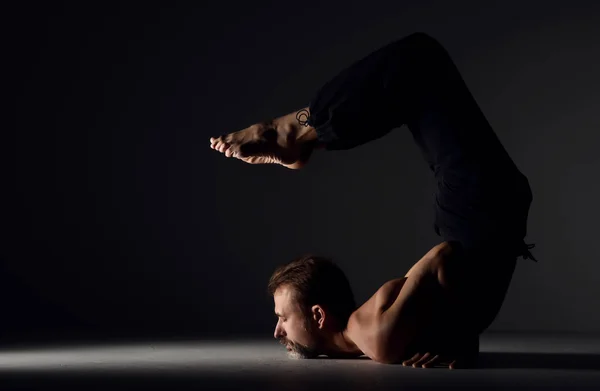 Mies harjoitellaan jooga skorpioni asana aiheuttaa — kuvapankkivalokuva