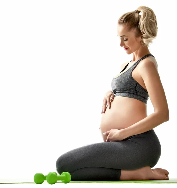 Zwangere vrouw doen sport stretching oefeningen groene gewichten. Zwangerschap moederschap verwachting gezond leven en gewicht bedieningsconcept — Stockfoto