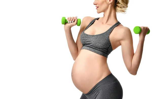 Mujer embarazada haciendo ejercicios de estiramiento deportivo pesos verdes. Embarazo maternidad expectativa vida sana y el concepto de control de peso —  Fotos de Stock