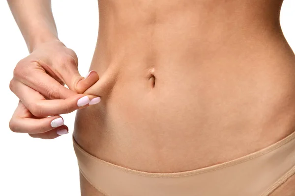 Woman holding fold of skin cellulite on female body concept isolated — Stock Photo, Image
