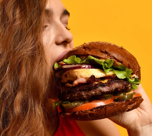 Sabroso sándwich de hamburguesa malsana en las manos de la mujer boca hambrienta preparándose para comer — Foto de Stock