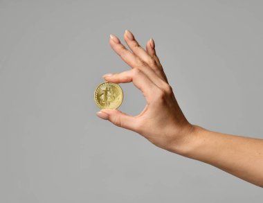 Elini tut altın bitcoin cryptocurrency gri arka plan üzerinde