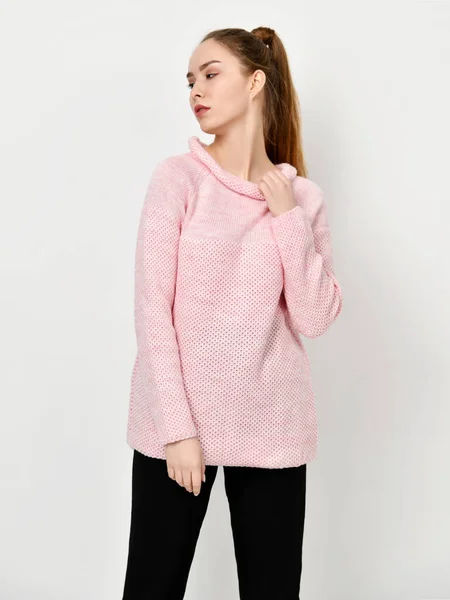 Jeune belle femme posant dans un nouveau pull rose décontracté — Photo