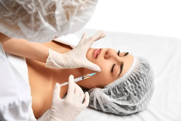 Cosmetología facial cirugía plástica concepto de belleza joven morena mujer recibiendo inyección de ácido hialurónico — Foto de Stock