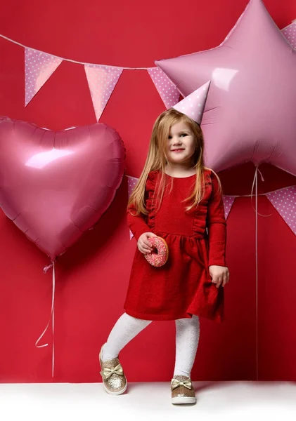 Adorable pretty girl with pink balloons and red present gift and birthday cap — Stock Photo, Image