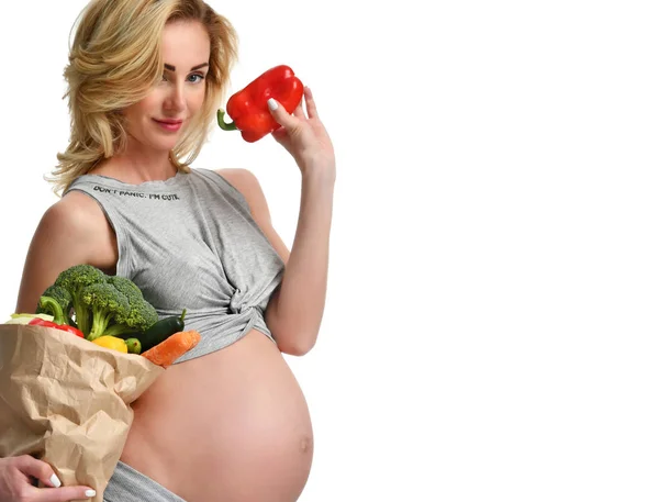 Беременная женщина держит сумку с органическими овощами из продуктового магазина. Ожидание беременности, здоровое питание и контроль веса — стоковое фото