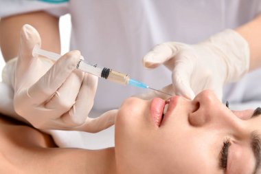 Plastik cerrahi güzellik kavramı genç esmer kadın yüz ve doktor şırınga ile el olarak eldiven