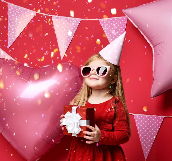 Adorabile bella ragazza con palloncini rosa e rosso regalo e cappello di compleanno — Foto Stock