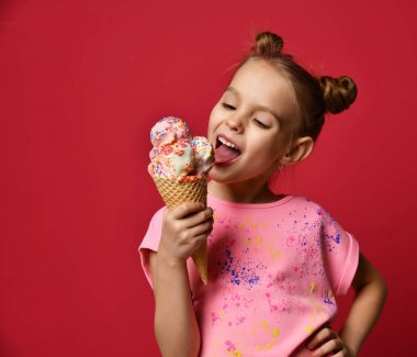 Güzel bebek kız çocuk büyük dondurma waffle koni ile Ahududu mutlu gülüyor yalama yeme