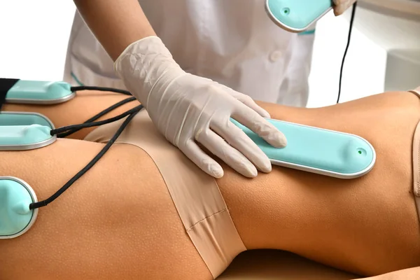 Woman getting anti-cellulite and anti-fat therapy on her tight buttocks in beauty salon. Body care. Ultrasound cavitation — Stock Photo, Image