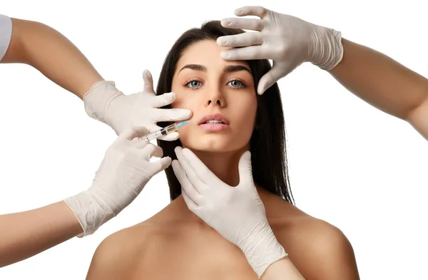 Plastische chirurgie schoonheid concept jonge brunette vrouw gezicht en arts hand in de handschoen met spuit — Stockfoto