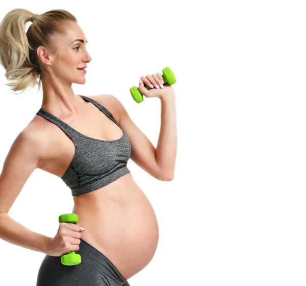 Mujer embarazada haciendo ejercicios de estiramiento deportivo pesos verdes. Embarazo maternidad expectativa vida sana y el concepto de control de peso —  Fotos de Stock