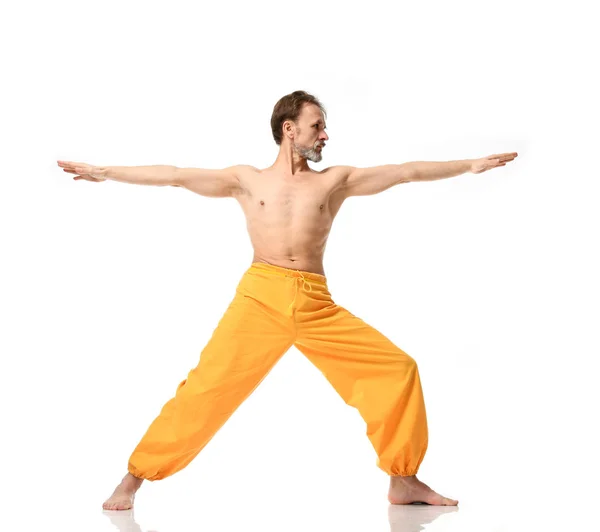 Viejo practicando yoga haciendo ejercicios de estiramiento deportivo en pantalones amarillos — Foto de Stock