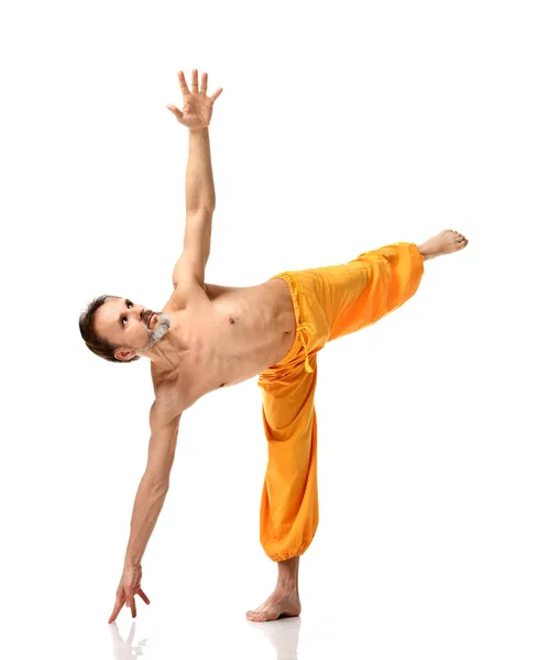 Gammal man praktisera yoga gör sport stretching övningar i gula byxor — Stockfoto