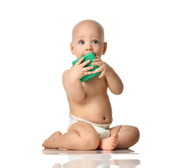 Infant child baby boy toddler sitting naked in diaper with green brick toy looking up — Stock Photo, Image