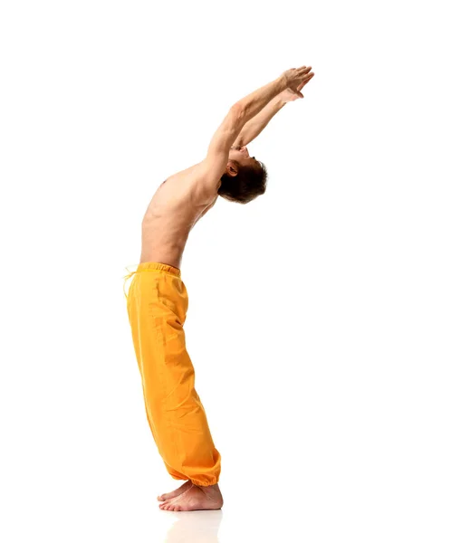 Viejo practicando yoga haciendo ejercicios de estiramiento deportivo en pantalones amarillos —  Fotos de Stock