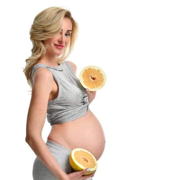 Vacker gravid kvinna hålla två hälften av pomelo frukt — Stockfoto