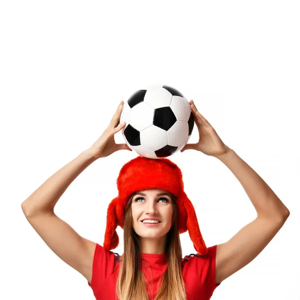Fan sport woman player in red uniform and russian winter hat hold soccer ball celebrating — Stock Photo, Image