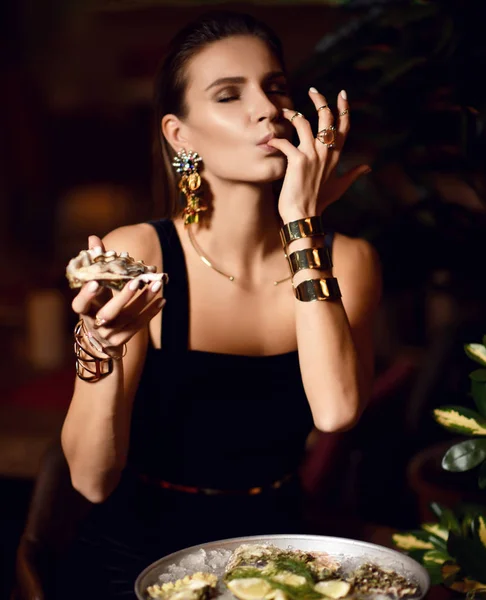 Hermosa mujer morena moda sexy en restaurante interior caro comer ostra y lamer un dedo — Foto de Stock