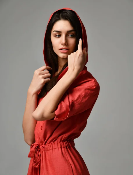 Молодая красивая женщина позирует в новом красном платье костюм с брюками и капюшоном — стоковое фото