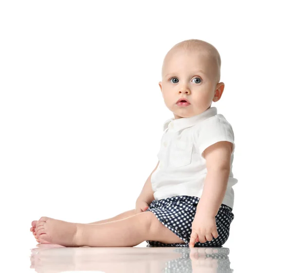 Ten month old infant baby boy with blue eyes sitting looking at the corner — Stock Photo, Image