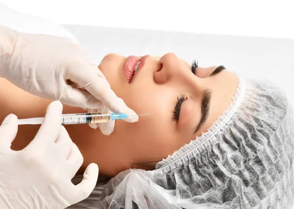 Plastic surgery beauty concept young brunette woman face and  doctor hand in glove with syringe