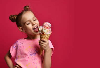 Güzel bebek kız çocuk büyük dondurma waffle koni ile Ahududu mutlu gülüyor yalama yeme