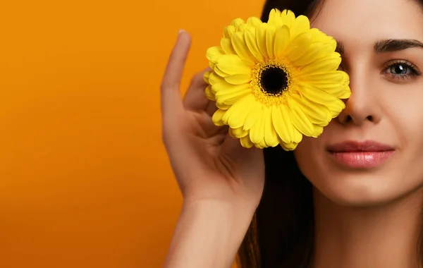 Young pretty woman hold yellow gerbera flower in green dress — Stock Photo, Image