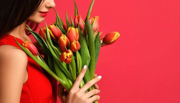 Belle femme avec bouquet de fleurs de tulipes en robe rouge — Photo