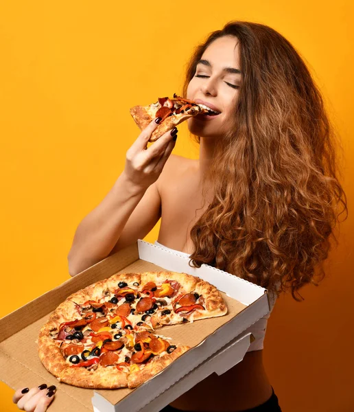 Νεαρή όμορφη γυναίκα τρώνε κομμάτι πίτσα πεπερόνι και κρατήστε ολόκληρη πίτσα στο πλαίσιο — Φωτογραφία Αρχείου
