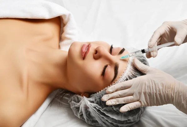 Plastic surgery beauty concept young brunette woman face and  doctor hand in glove with syringe — Stock Photo, Image