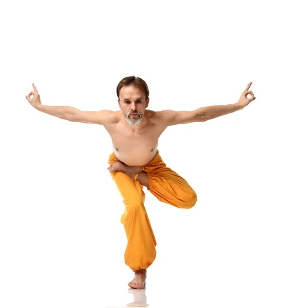 Ο άνθρωπος κάνει γιόγκα κάνει αθλητισμό διατατικές ασκήσεις στο κίτρινο παντελόνι — Φωτογραφία Αρχείου